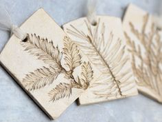 three wooden tags with leaves on them