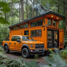 an orange truck parked in front of a house made out of shipping containers on the side of a forest