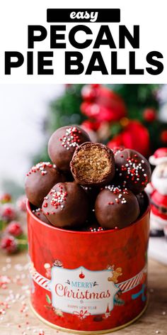 a red tin filled with chocolate covered christmas candy and sprinkles on top of it