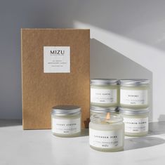 four candles in front of a box with the label mizu