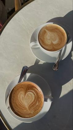 two cups of cappuccino on a table