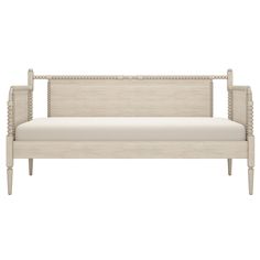 an upholstered daybed with white linen and beading