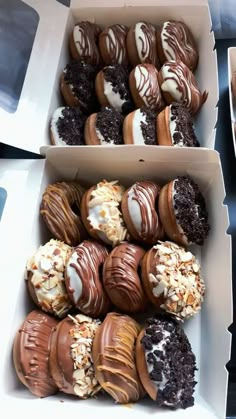 two boxes filled with assorted chocolate covered donuts