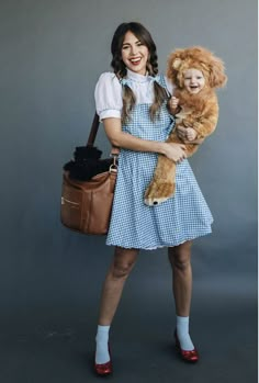 a woman is holding a teddy bear and smiling at the camera while posing for a photo