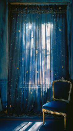 a chair sitting in front of a window with blue curtains and stars on the curtain