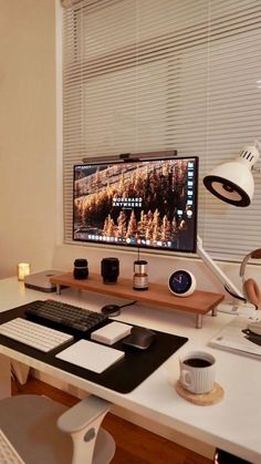 a desktop computer sitting on top of a white desk next to a lamp and keyboard