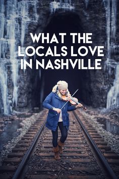 a woman playing violin on train tracks with the words what the locals love in nashville