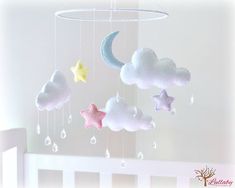 a crib mobile with clouds, stars and rain drops hanging from it's sides