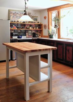 a kitchen with an island in the middle and shelves on the wall next to it