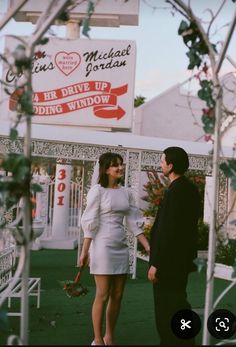 a man standing next to a woman in a white dress