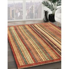 an area rug with multicolored stripes on the floor in front of a window