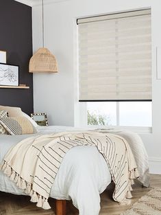 a bedroom with black walls and white bedding