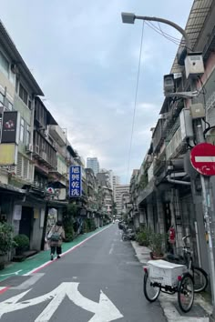 an empty street with buildings and people walking on the sidewalk