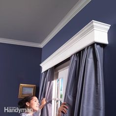 a bedroom with blue walls and white trim on the ceiling, along with an open window