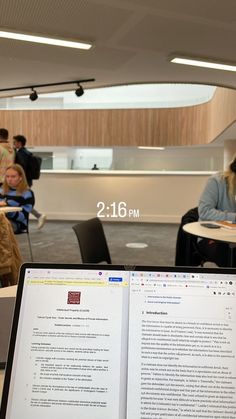 an open book sitting on top of a table in front of a laptop computer screen