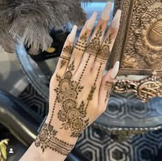 a woman's hand with henna tattoos on it