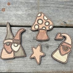 four wooden cutouts of different shapes and sizes on a wood table with one being a mushroom, the other is a star