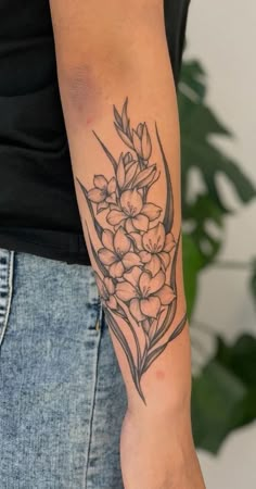 a woman's arm with a flower tattoo on the left side of her arm