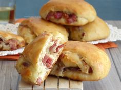 ham and cheese crescent pastries sitting on top of a wooden table