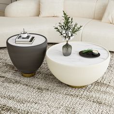 a white couch sitting next to a table on top of a rug