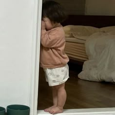 a small child standing in front of a mirror