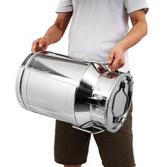 a man is holding a large silver barrel shaped object in his hands and it's attached to the handle