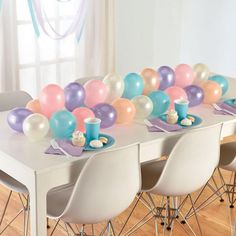 the table is set with balloons and plates