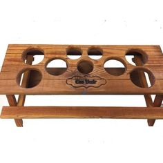 a wooden tray with holes in the middle and two legs on each side, holding four cups