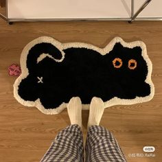 a person standing in front of a black cat rug