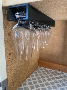 three clear vases are hanging from the wall