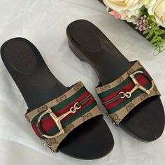 Authentic Gucci Clogs With Classic Gucci Red And Green Sherry And Saddle Design. It Has Scratches Around The Shoes And Coating Peelings But Still Has A Lot Of Life Left. Size 6.5. Please Review All Pictures Closely For The Flaws And Manage Your Expectations As These Flats Are Priced Based On Its Condition. No Returns Please And Price Is Firm!!! Gucci Open Toe Mules With Branded Heel Counter, Gucci Flat Slides With Branded Insole, Gucci Clogs, Gucci Luxury Round Toe Mules, Red Gucci Slides With Branded Insole, Gucci Mules With Horsebit Detail, Round Toe, Saddle Design, Gucci Shoes, Mule Clogs