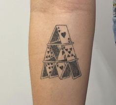 a tattoo on the leg of a person with playing cards and hearts drawn on it