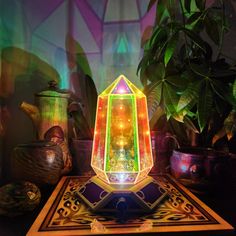 a colorful lamp sitting on top of a table next to potted plants