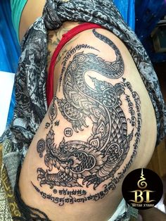 a woman's stomach with an intricate dragon tattoo on it