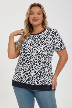 a woman wearing a white and black leopard print top