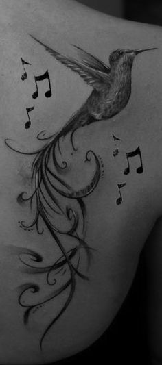 a woman's back with a bird tattoo on it