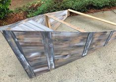 a wooden boat sitting on top of a cement ground