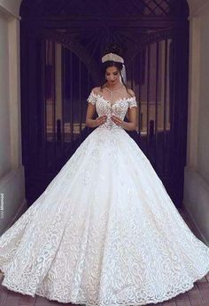 a woman standing in front of a doorway wearing a white wedding dress and tiara