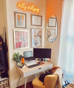 a desk with a laptop computer sitting on top of it next to a wall covered in pictures