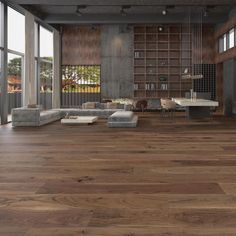 a living room filled with lots of furniture next to large open windows and wooden floors