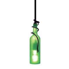 a green glass bottle with a black cord hanging from it's neck and the light is on