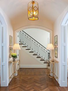 an open floor plan for a home with wood floors and chandelier above the stairs