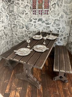 a wooden table and benches in a room with wall paper on the walls behind it