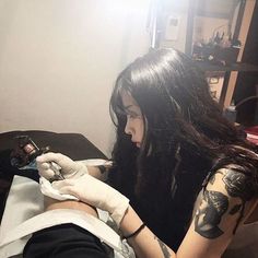 a woman is getting her tattoo done by someone in the room with no one around