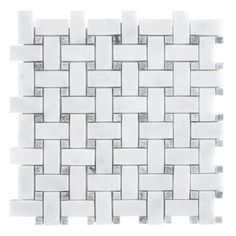 a white tile wall with grey and gray squares on the bottom, in an irregular pattern