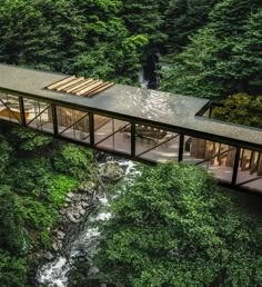 an aerial view of a house in the middle of a forest with a river running through it