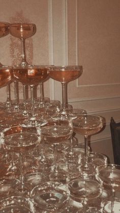 a table topped with lots of glasses filled with liquid and wine goblets sitting on top of each other