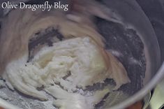 a mixing bowl filled with batter on top of a wooden table