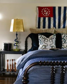 a bed with blue and white comforter in a bedroom next to two lamps on either side of the bed