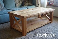 a wooden table sitting on top of a carpeted floor next to a blue couch